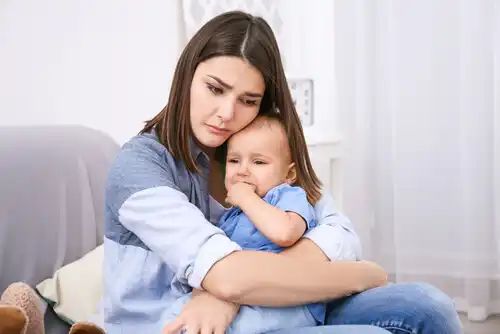 a woman holding a crying baby