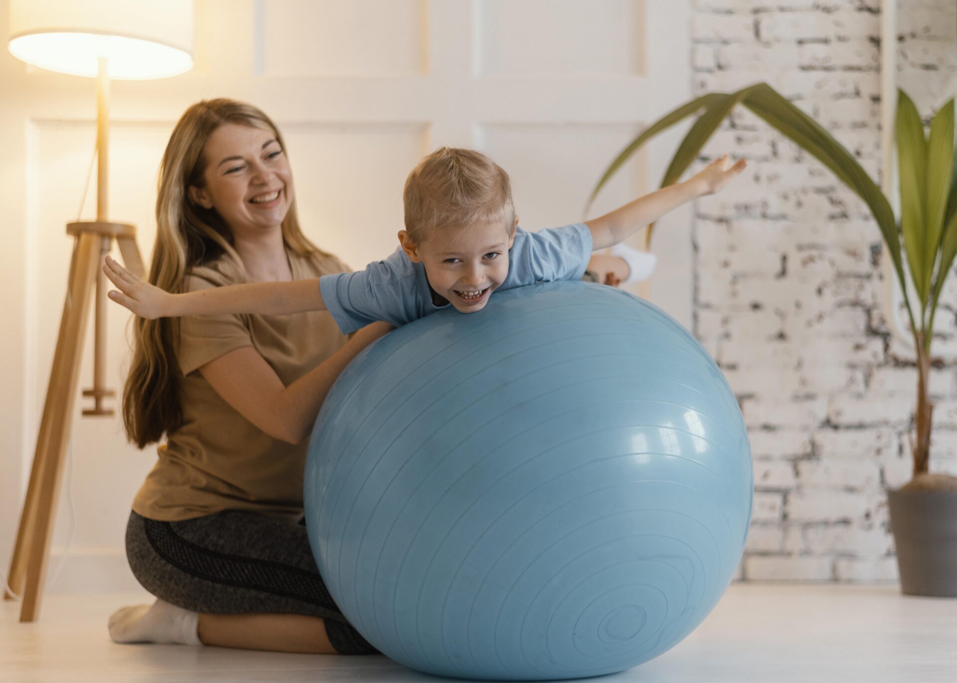 full shot woman holding kid gym ball