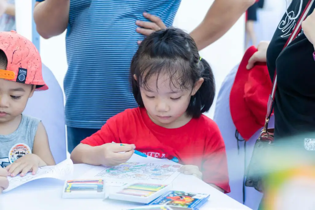 a girl coloring on a table